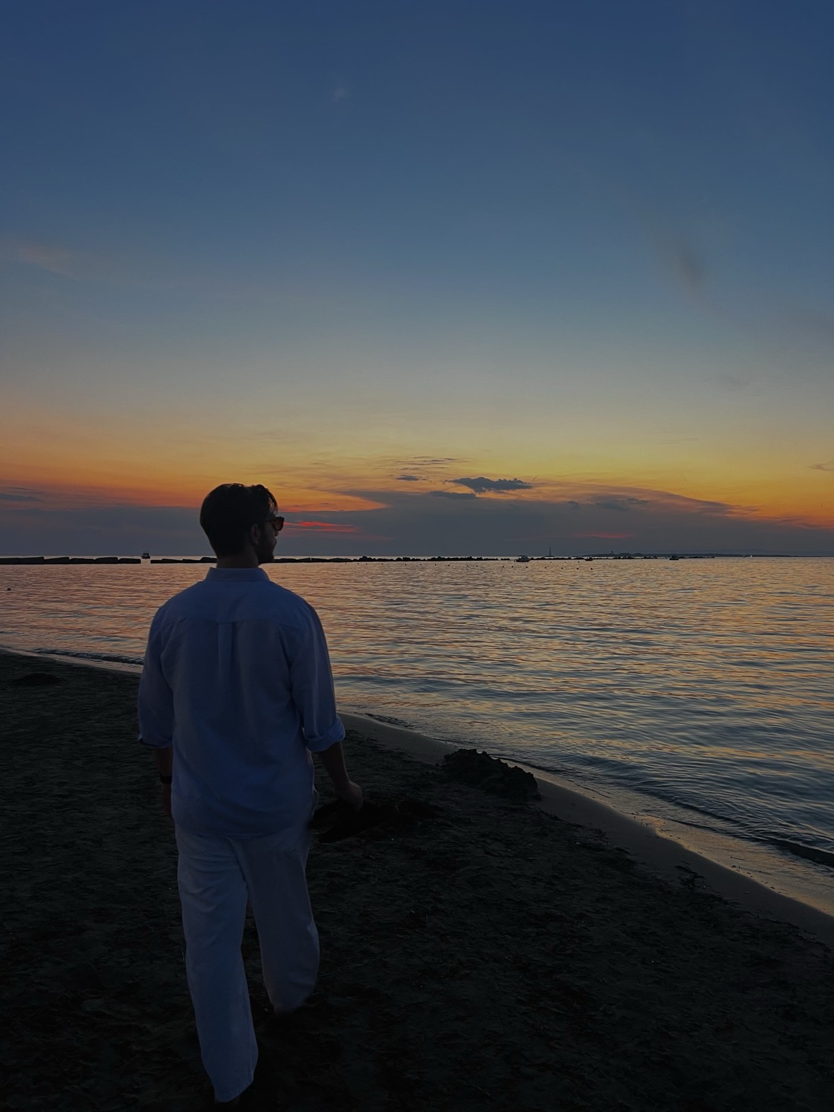 Gabriele walking by the sea at sunset
